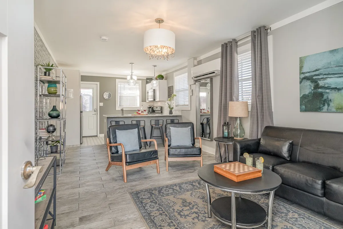 A cozy living room setup featuring a plush sofa, a modern coffee table, comfortable seating, and contemporary artwork on the wall. The layout invites groups to gather for socializing, playing board games, or simply relaxing together.